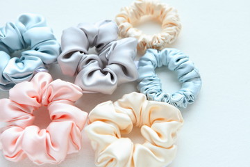 Lot of Colorful silk Scrunchies on white. Flat lay Hairdressing tools and accessories. Hair Scrunchies, Elastic HairBands, Bobble Sports Scrunchie Hairband