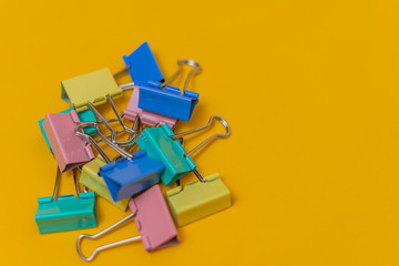 multi-colored paper clips on a yellow background