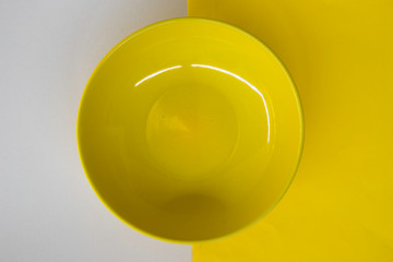 Empty yellow ceramic plate on white clear background, glossy bowl, weight loss diet, anorexia