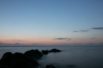 blue hour by the sea with rock silhouettes