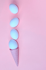 Vertical image of white eggs and wafer cone on pink background. Abstract food background.