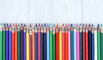  brushes in a row with faces and funny grimace over white wooden background, top view, above