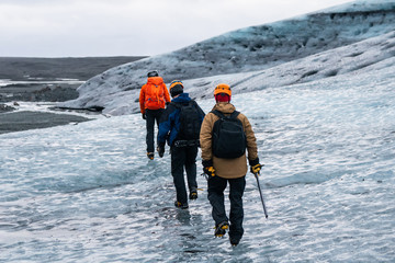 Tourists in helmets and crampons exploring the glacier surface