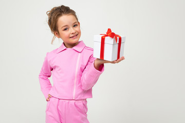 joyful happy caucasian girl holding a box with a gift with a red ribbon for a birthday on a white...