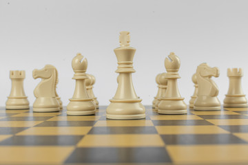 White figures in a row on a chessboard on isolated white background