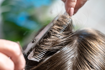 Hair cutting with a comb and scissors blurred in motion.