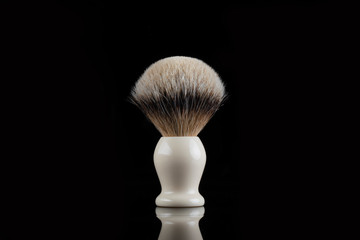 Fototapeta na wymiar Traditional shaving brush in front of black background. Shaving brush made of badger hair.