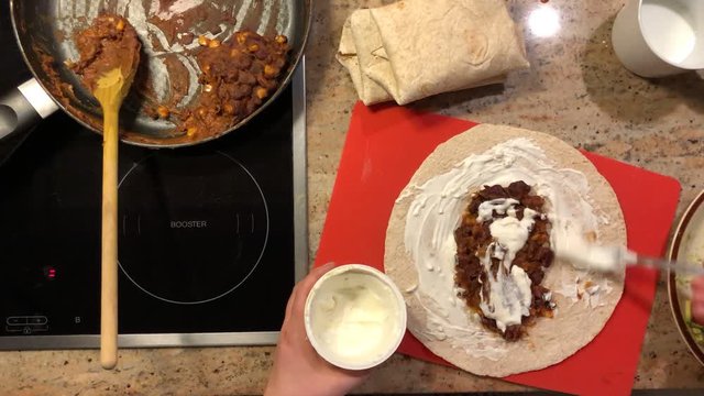 Bird view, time lapse of making tortillas with guacamole, beans, tomatoes, mayonnaise etc.