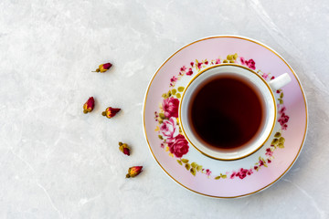Top view of a cup of tea with dried roses