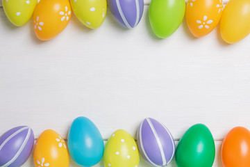 Colorful Easter eggs on white wooden table