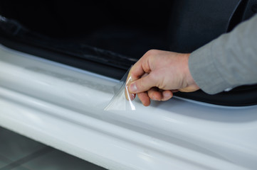 Worker hands installs car paint protection film