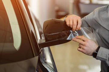 Worker hands installs car paint protection film