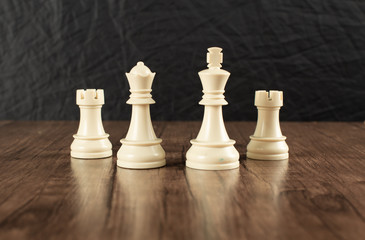 White powerful chess figures on a wooden desk