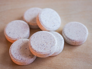 Vitamin pills on wooden table, selective focus.