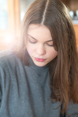 Fototapeta premium Young woman looking down absorbed in her own thoughts or concentrating