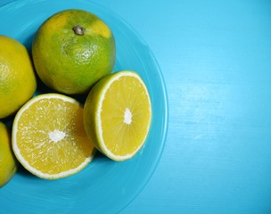 Fototapeta na wymiar halved oranges on blue monochromatic stage