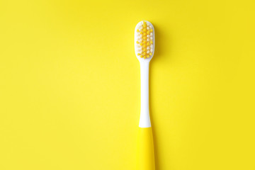 Toothbrush on a yellow background. Dental concept. Minimal composition with a copy space.