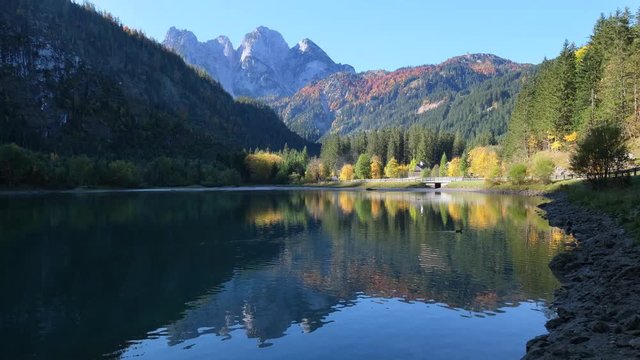 Peaceful autumn Alps mountain lake. Gosauseen or Vorderer Gosausee lake, Upper Austria. Dachstein summit and glacier in far.