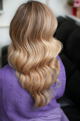 Naklejka premium Blond woman with hairstyle of long wavy hair