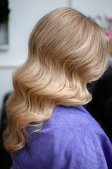 Naklejka premium Blond woman with hairstyle of long wavy hair