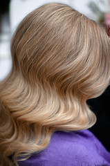 Naklejka premium Blond woman with hairstyle of long wavy hair