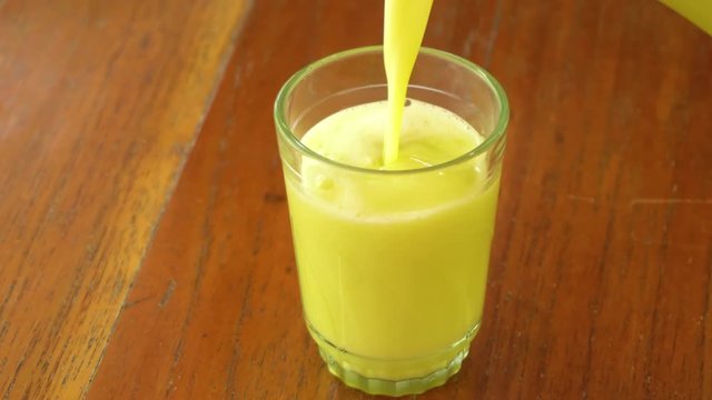 close-up serving naranjilla juice in a glass cup