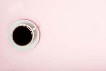 white cup with coffee on a pink background, minimalism