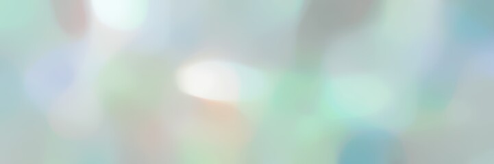 blurred bokeh landscape format background with pastel blue, beige and dark gray colors and space for text