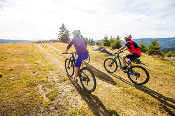Fototapeta na wymiar cyclists riding through mountain landscape in sunlight