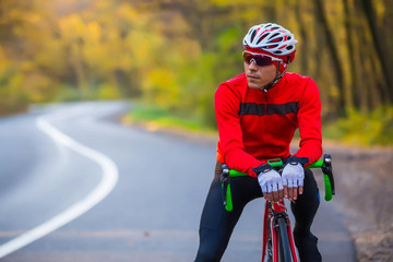 young man in bikers clothes riding a racing bicycle