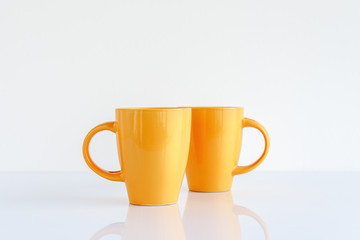 Two yellow coffee cups on the table