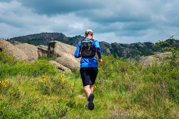 Athlete runner running on a mountain trail