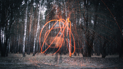 Sparks from steel wool in the evening forest