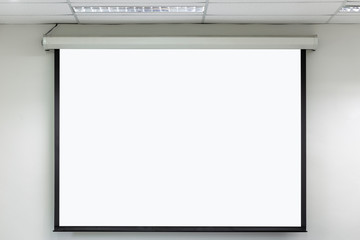 Front view of lecture room with empty white projector screen.