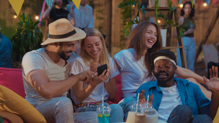 Best friends multi-race cheerful young people taking silly selfie pictures with funny expressions while chilling on summer party.