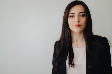 Obraz premium Young attractive emotional girl in business-style clothes on a plain white background in an office or audience