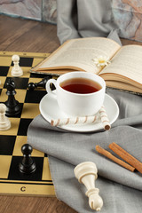 A cup of tea and a chessboard
