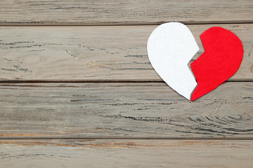 Broken fabric heart on wooden table