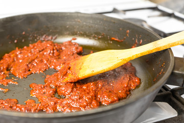 Cooking tomato sauce in a frying pan.