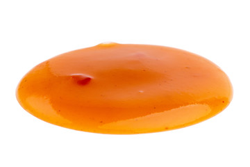 Dripping orange sauce isolated on white background with clipping path. Flat lay, top view, close up.