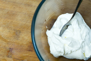 Natural sour cream in a glass plate.