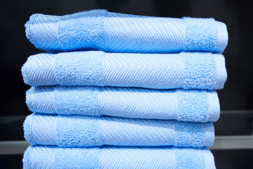 Soft blue fiber towels on a shelf in a store. Terry blue towels. Close-up