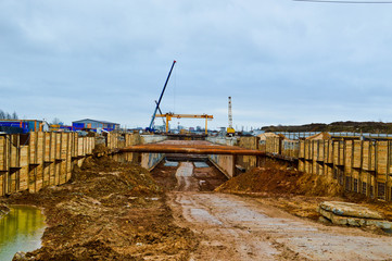 A construction site with specialized professional equipment and cranes during the construction of a modern line of the underground metro station in the big city of the metropolis