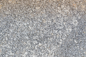 Gray asphalt road with small pebbles and cracks. Texture, background