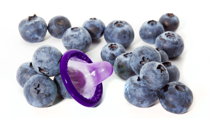 Unwrapped color condom with fruit flavor and blueberries