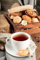 A cup of tea with biscuits tray around