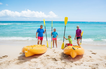 Happy family with kayaks at the tropical beach during summer vacations. Summer, sea , sport and fun ..