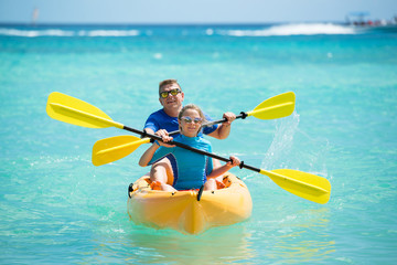 Happy family with kayaks during summer vacations. Father and daughter enjoy the time together .