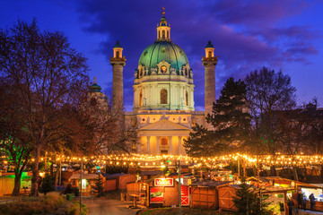 Fototapeta na wymiar Festive cityscape - view of the Christmas Market on Karlsplatz (Charles' Square) and the Karlskirche (St. Charles Church) in the city of Vienna, Austria