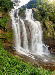 Beautiful photo of big waterfall in the jungle forest at sunset